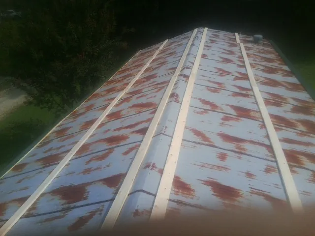 Rusted metal roof panels with new wood purlins before replacement — Storm Damage Roof Repair in Reddell by Roofing Brothers